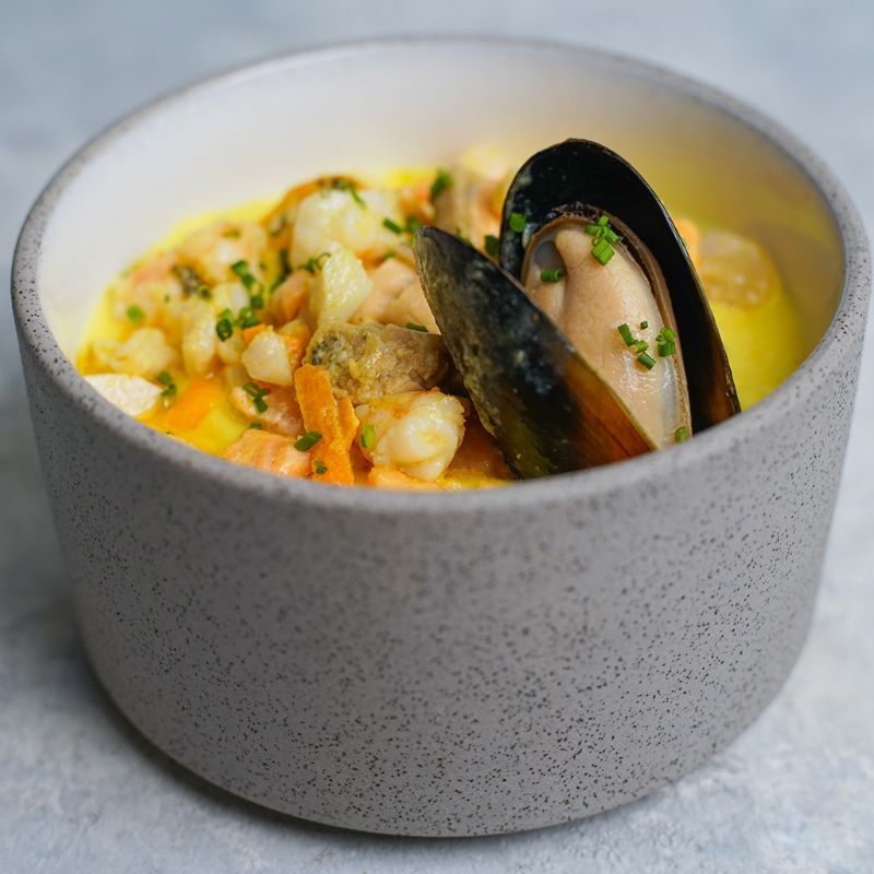 A bowl of Mediterranean seafood soup on a table