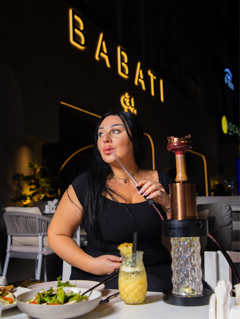 Woman enjoying shisha, showcasing a luxury experience in Business Bay-