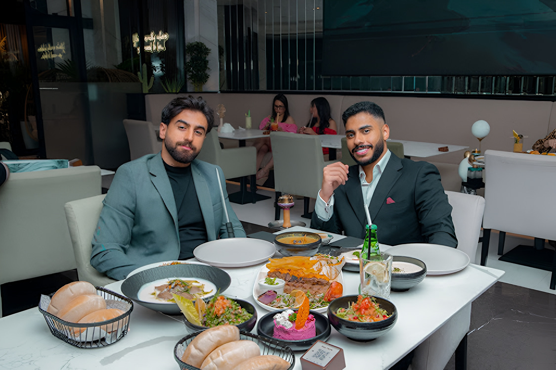Two businessmen enjoying a professional lunch meeting at Babati Dubai with a table full of Middle Eastern dishes