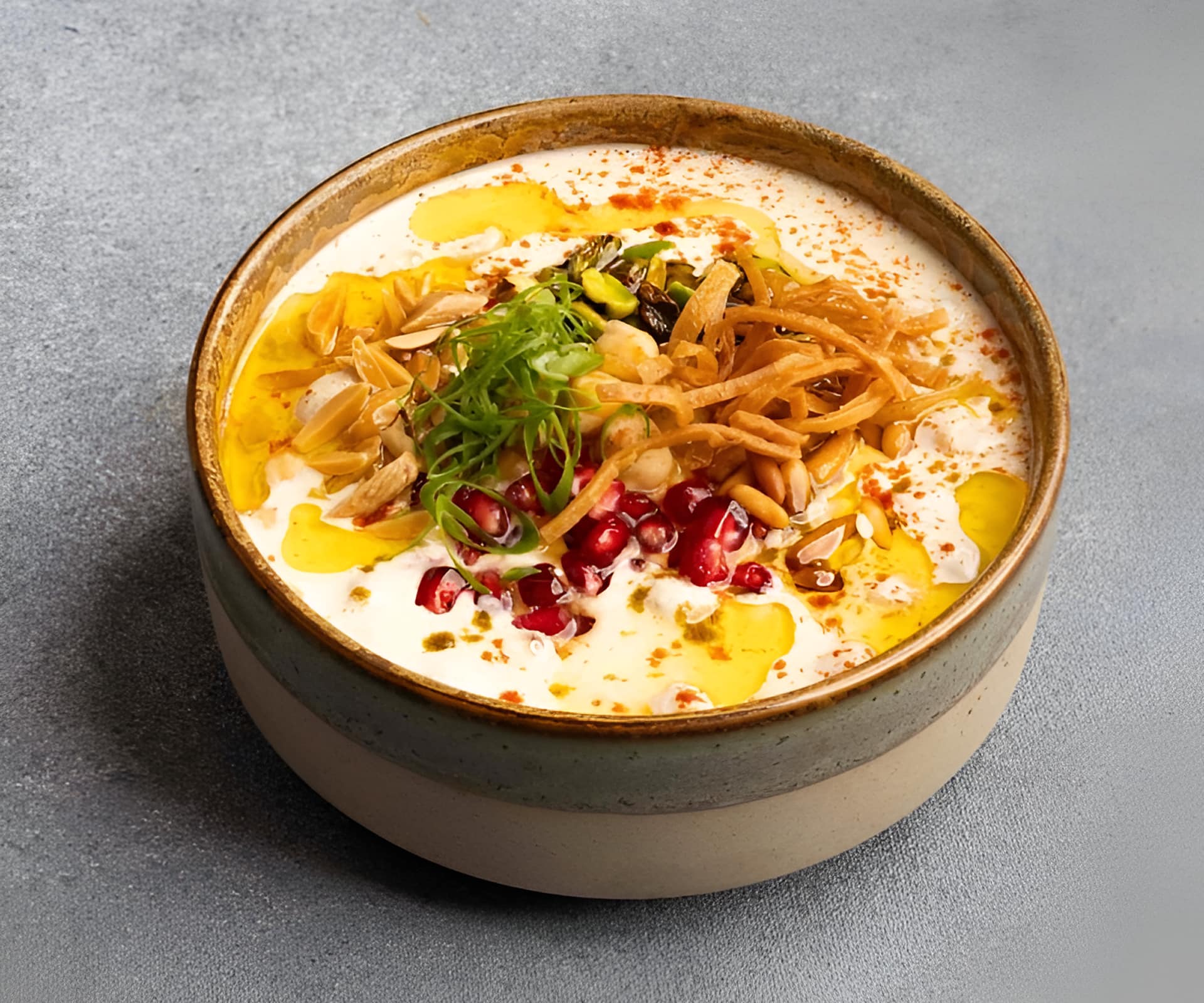Bowl of traditional Lebanese foul medames breakfast topped with yogurt.