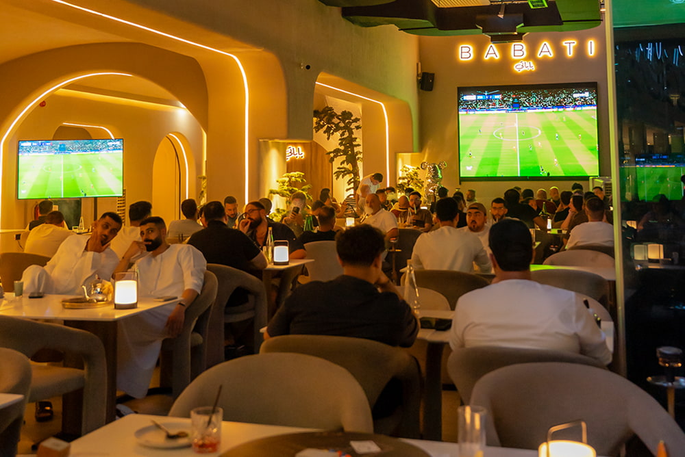 Packed indoor seating area and stylish ambiance at Babati Lebanese Restaurant and Shisha Lounge in Business Bay Dubai during a live sports screening.