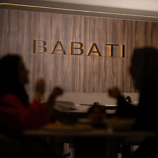 Babati Lebanese Restaurant and lounge indoor seating area with illuminated wall logo.