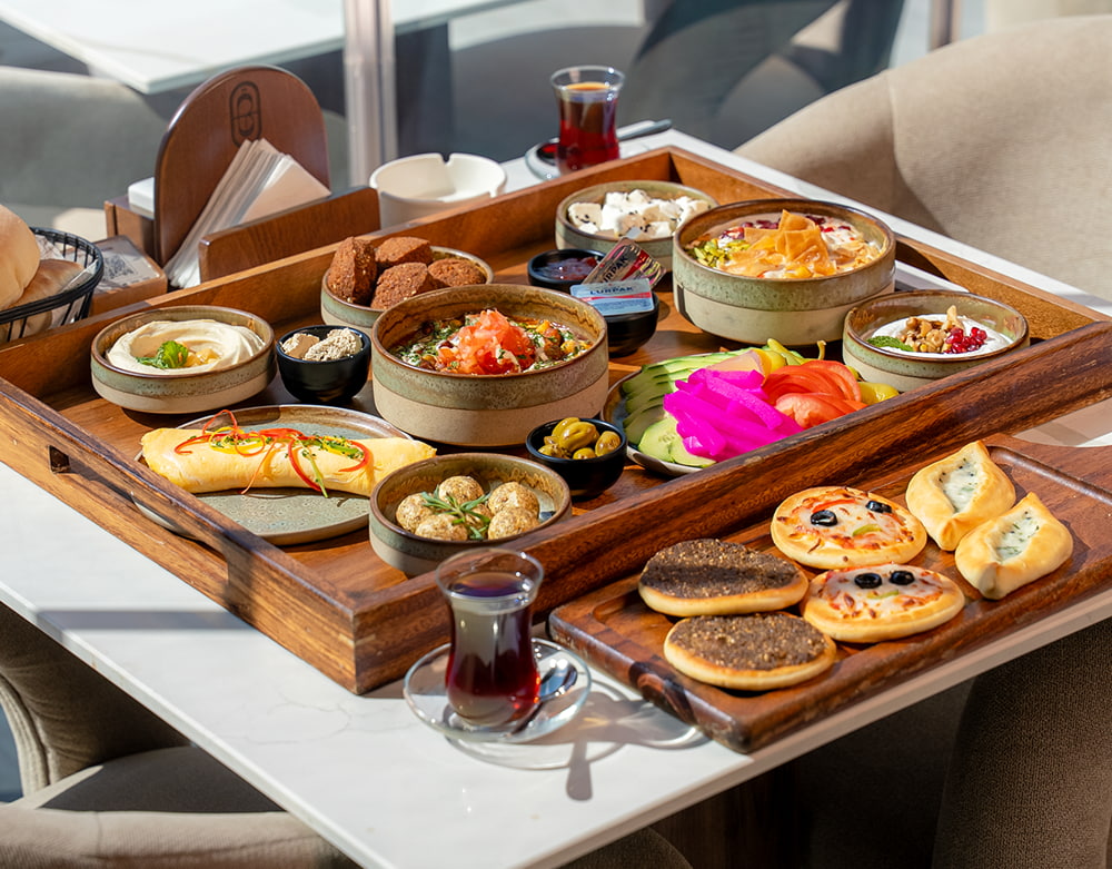 Authentic Lebanese Arabic breakfast platter at Babati Restaurant Dubai featuring hummus, falafel, fresh manakish, omelet, and traditional tea.